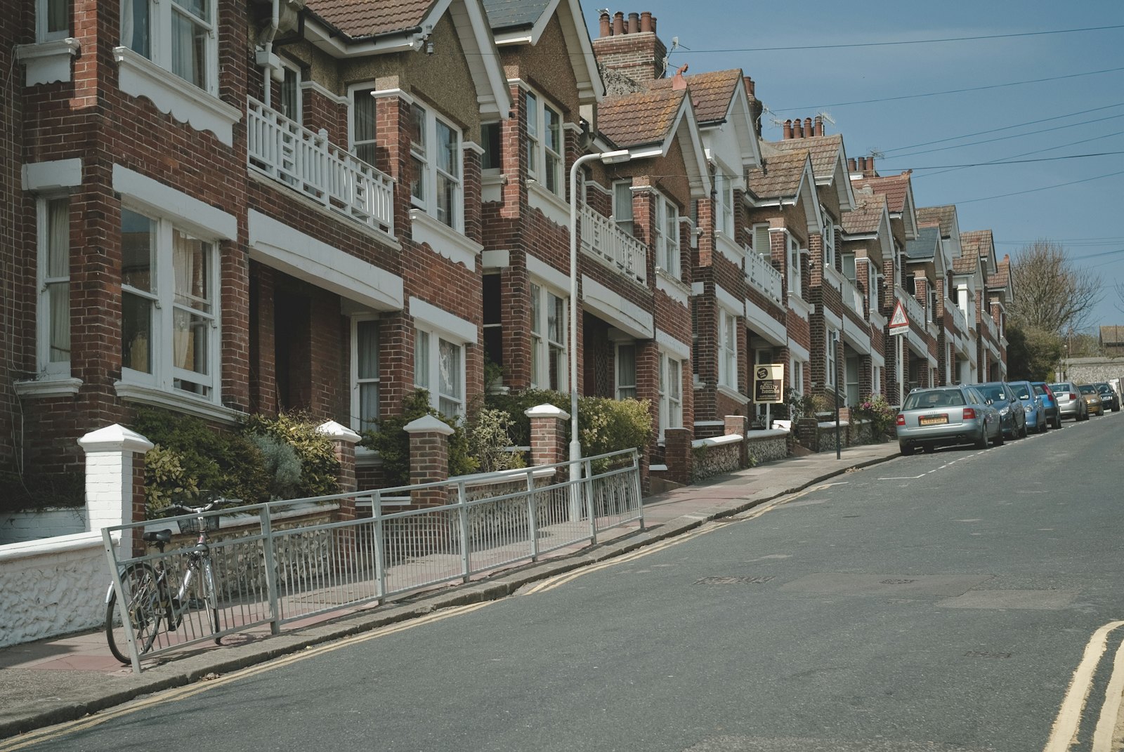 A row of red-brick Victorian terraced houses on a residential UK street